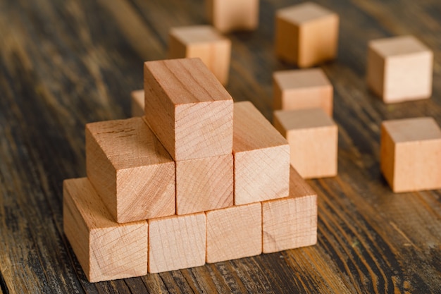 Concepto de crecimiento empresarial con la pirámide de cubos de madera en la vista de ángulo alto de mesa de madera.