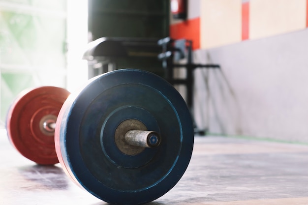 Concepto de culturismo con barra de pesas en gimnasio