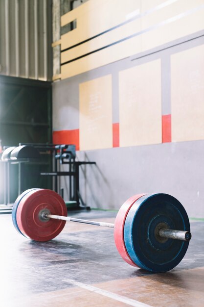 Concepto de culturismo con barra de pesas en gimnasio