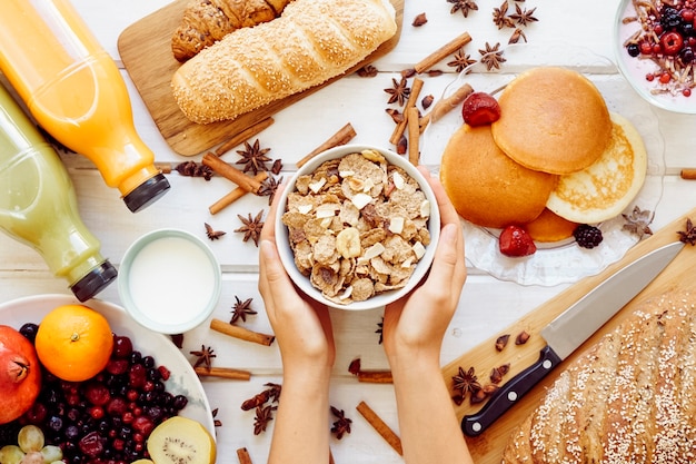 Concepto de desayuno saludable con manos sujetando cereales