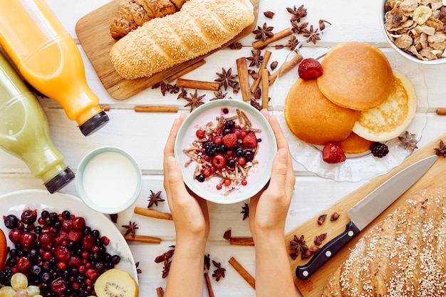 Concepto de desayuno saludable con manos sujetando yogur