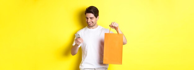 Concepto de descuentos en banca en línea y devolución de dinero chico feliz mostrando bolsa de compras y mirando satisfecho