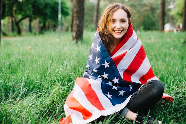 Foto gratuita concepto del día de la independencia con chica sentada en el bosque