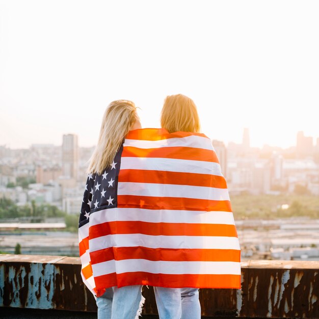 Concepto para el día de la independencia con chicas en techo mirando hacia ciudad