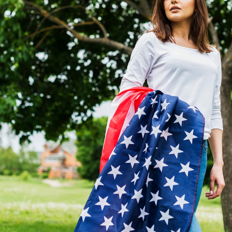 Foto gratuito concepto para el día de la independencia con mujer y bandera americana enfrente de árbol