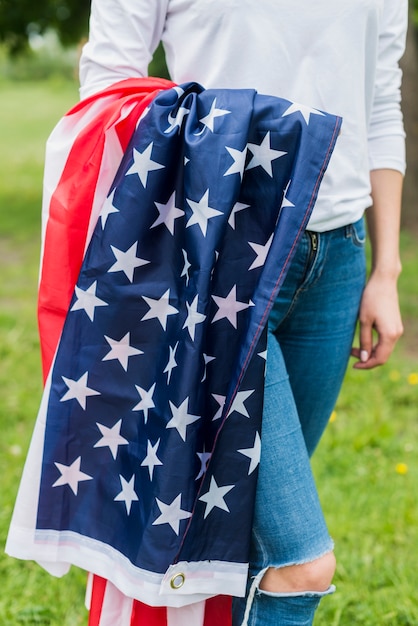 Concepto para el día de la independencia con mujer llevando bandera americana