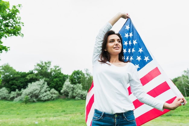 Concepto para el día de la independencia con mujer sujetando bandera americana