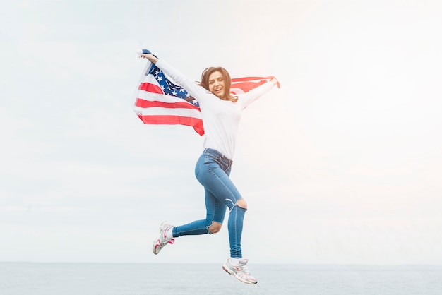 Concepto para el día de la independencia con mujer sujetando bandera sobre fondo de cielo