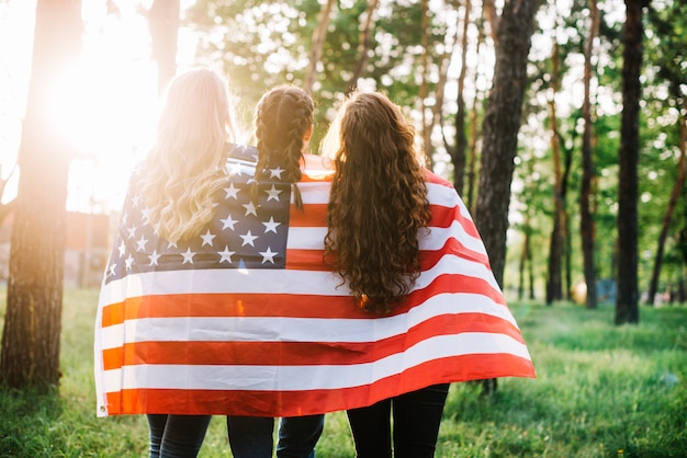 Concepto del día de la independencia con vista trasera de chicas en el bosque