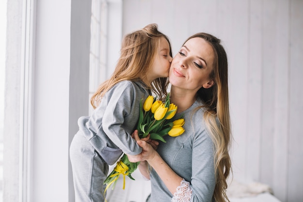 Concepto del día de la madre con hija besando madre