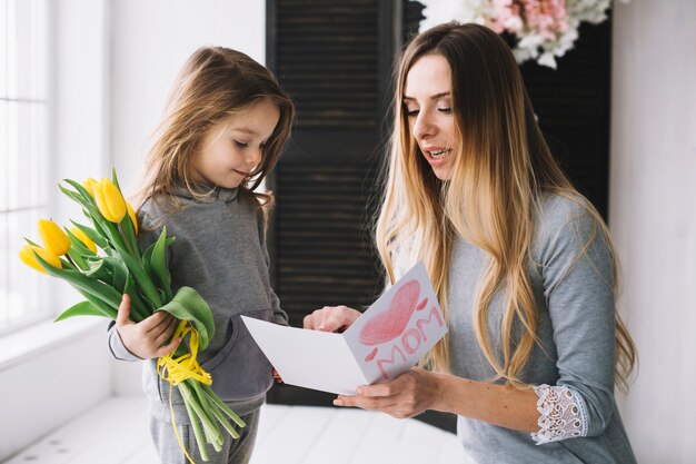 Concepto del día de la madre con hija sujetando flores