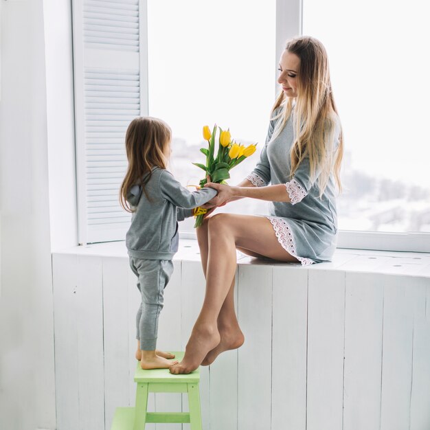 Concepto del día de la madre con madre e hija con flores amarillas