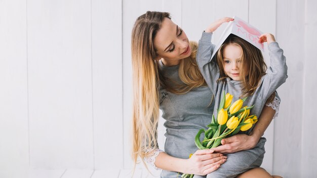 Concepto del día de la madre con madre e hija sujetando flores