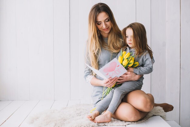 Concepto del día de la madre con madre e hija sujetando tarjeta