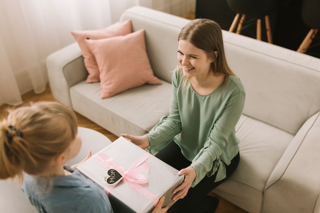 Concepto para el día de la madre con niña dando regalo