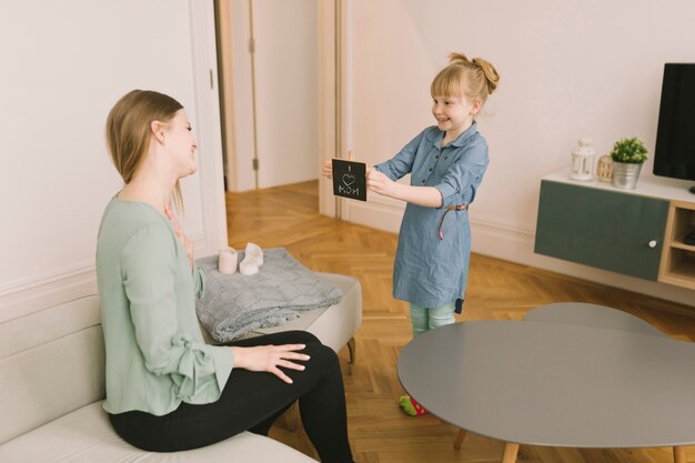 Concepto para el día de la madre con niña enseñando tabla