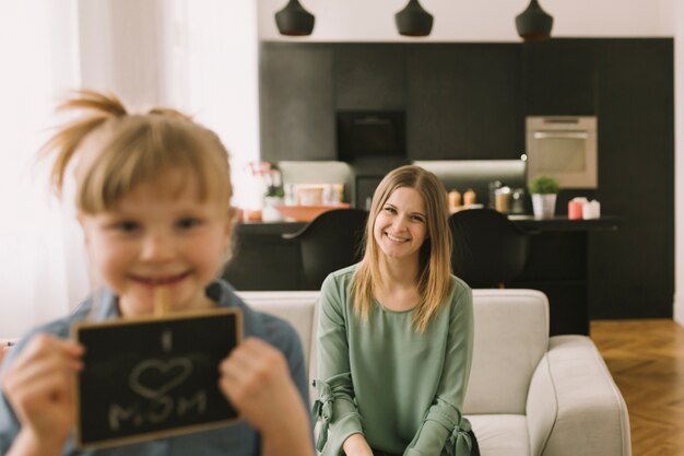 Concepto para el día de la madre con niña sujetando tabla