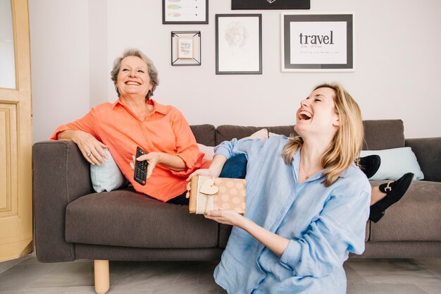 Concepto para el día de la madre con regalo e hija riendo