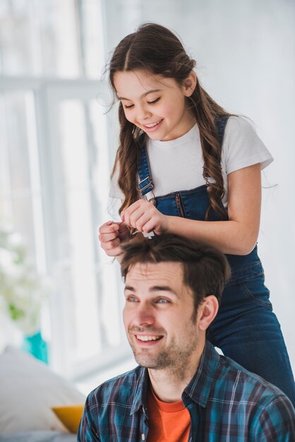 Concepto para el día del padre con hija cortando pelo del padre