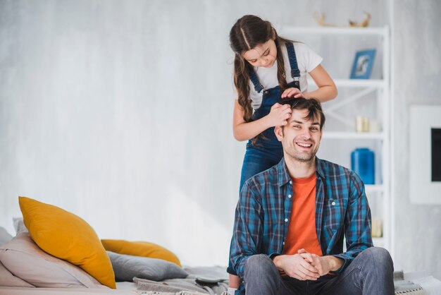 Concepto para el día del padre con hija cortando pelo del padre