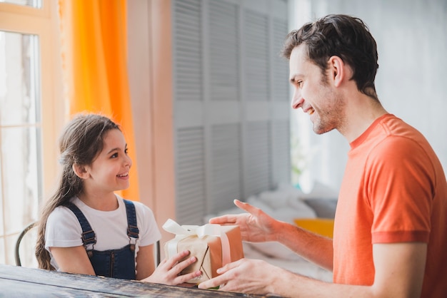 Concepto para el día del padre con hija dando caja de regalo