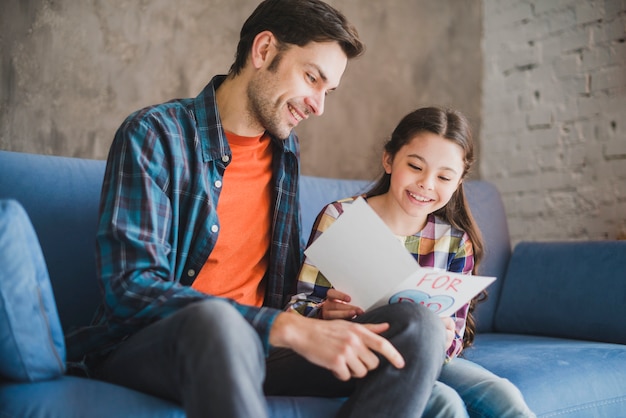 Foto gratuita concepto para el día del padre con hija enseñando tarjeta