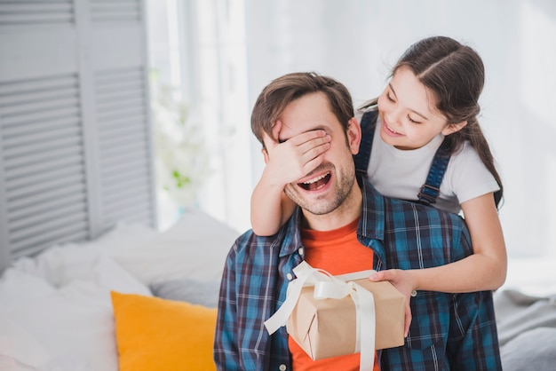 Concepto para el día del padre con hija tapando ojos del padre