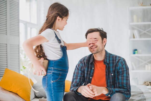 Concepto para el día del padre con hija tapando ojos del padre