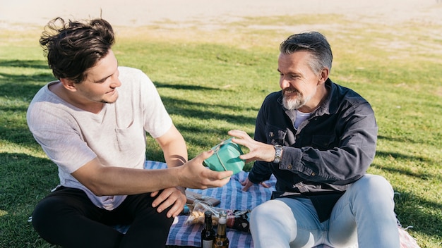 Concepto del día del padre con hijo dando regalo a padre