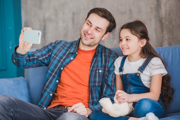 Concepto para el día del padre con padre e hija haciendo selfie