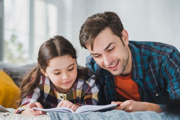 Concepto para el día del padre con padre e hija leyendo