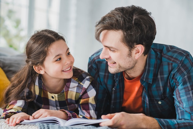 Concepto para el día del padre con padre e hija leyendo