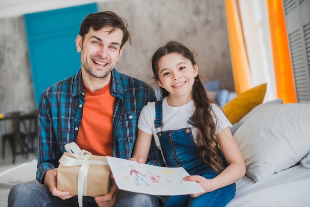 Concepto para el día del padre con padre e hija sujetando regalos