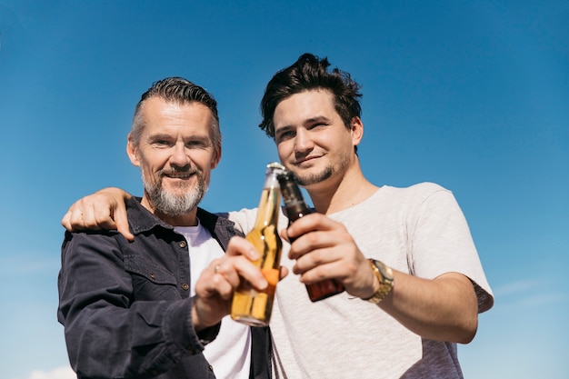 Concepto del día del padre con padre e hijo posando con cerveza