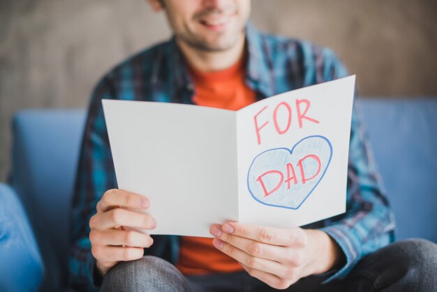 Concepto para el día del padre con padre mirando a tarjeta dibujada a mano