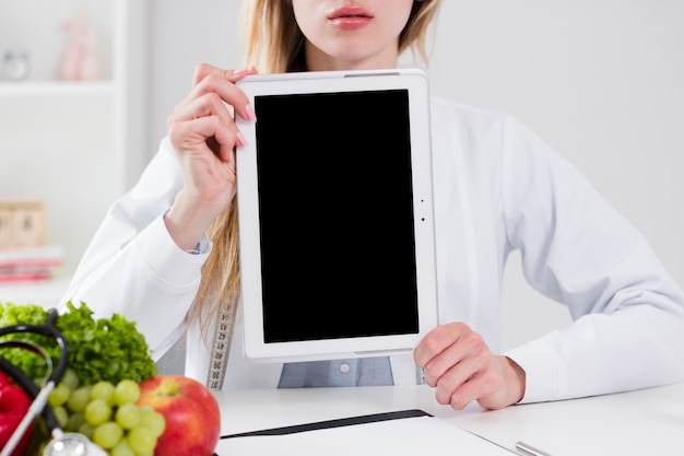Concepto de dieta con científica enseñando plantilla de tableta