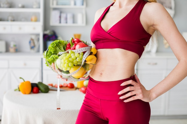 Concepto de dieta con mujer deportiva en la cocina