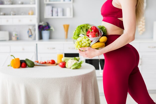 Concepto de dieta con mujer deportiva en la cocina