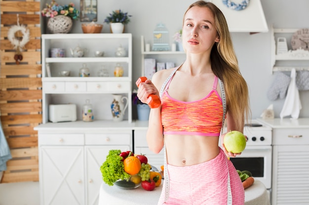 Concepto de dieta con mujer deportiva en la cocina