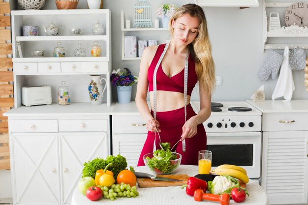 Concepto de dieta con mujer deportiva en la cocina