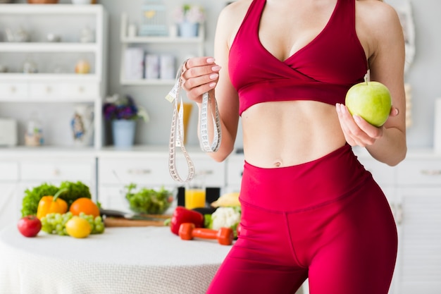 Concepto de dieta con mujer deportiva en la cocina