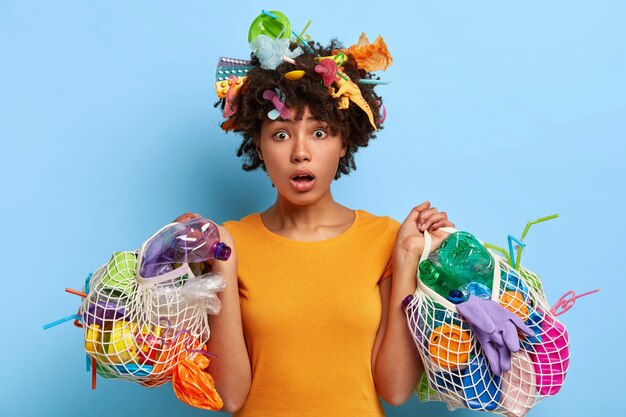 Concepto de ecología y medio ambiente. Mujer emocional de piel oscura apoya la reducción de la basura