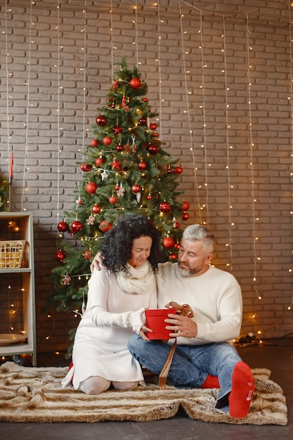 Concepto de edad y personas. Pareja mayor en casa. Mujer con un suéter de punto blanco.