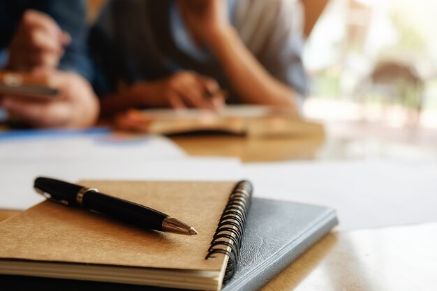 Concepto de educación. Estudiante, estudiar, brainstorming, campus, concepto Cerca de los estudiantes que discuten su tema en libros o libros de texto. Enfoque selectivo.