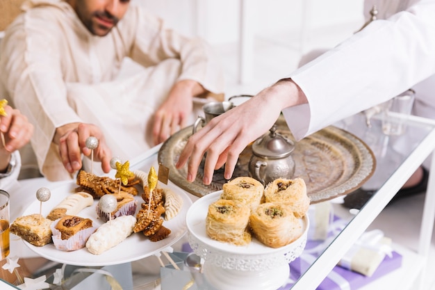 Concepto de eid al-fitr con comida árabe y amigos