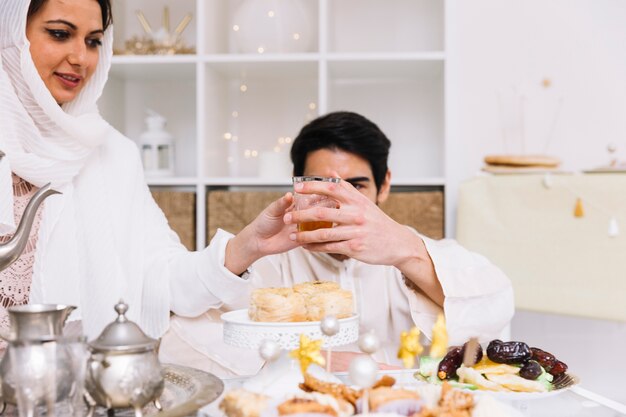 Concepto de eid al-fitr con con gente comiendo en mesa