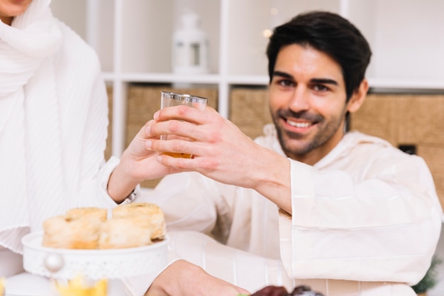 Concepto de eid al-fitr con con gente comiendo en mesa