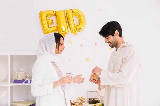 Concepto de eid al-fitr con pareja comiendo galletas