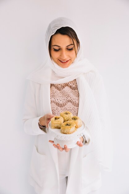 Concepto de eid con mujer sujetando pasteles árabes