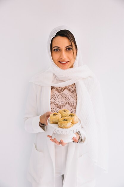 Concepto de eid con mujer sujetando pasteles árabes